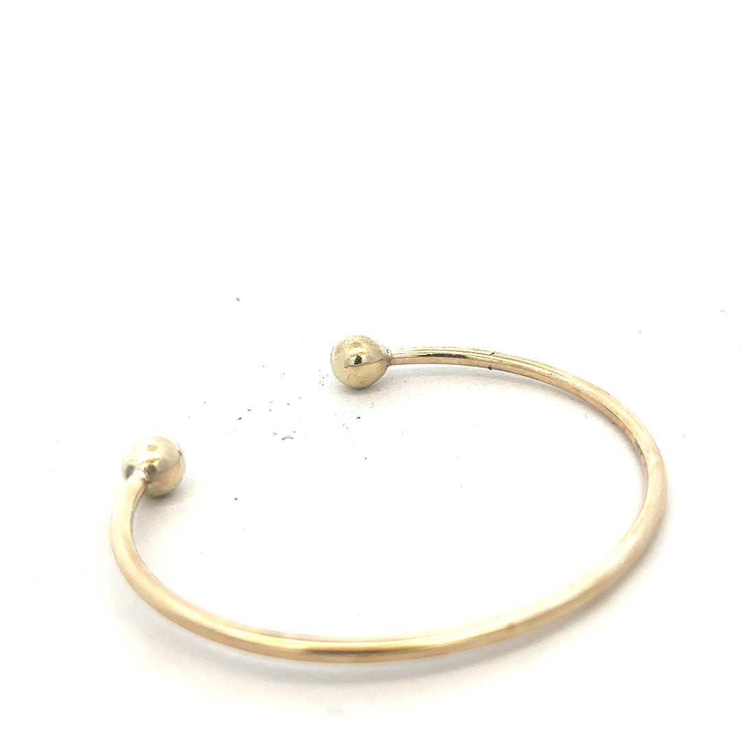 9ct yellow gold bangle bracelet weighing 12.7g with a simple, elegant unbranded design, shown on a plain background.