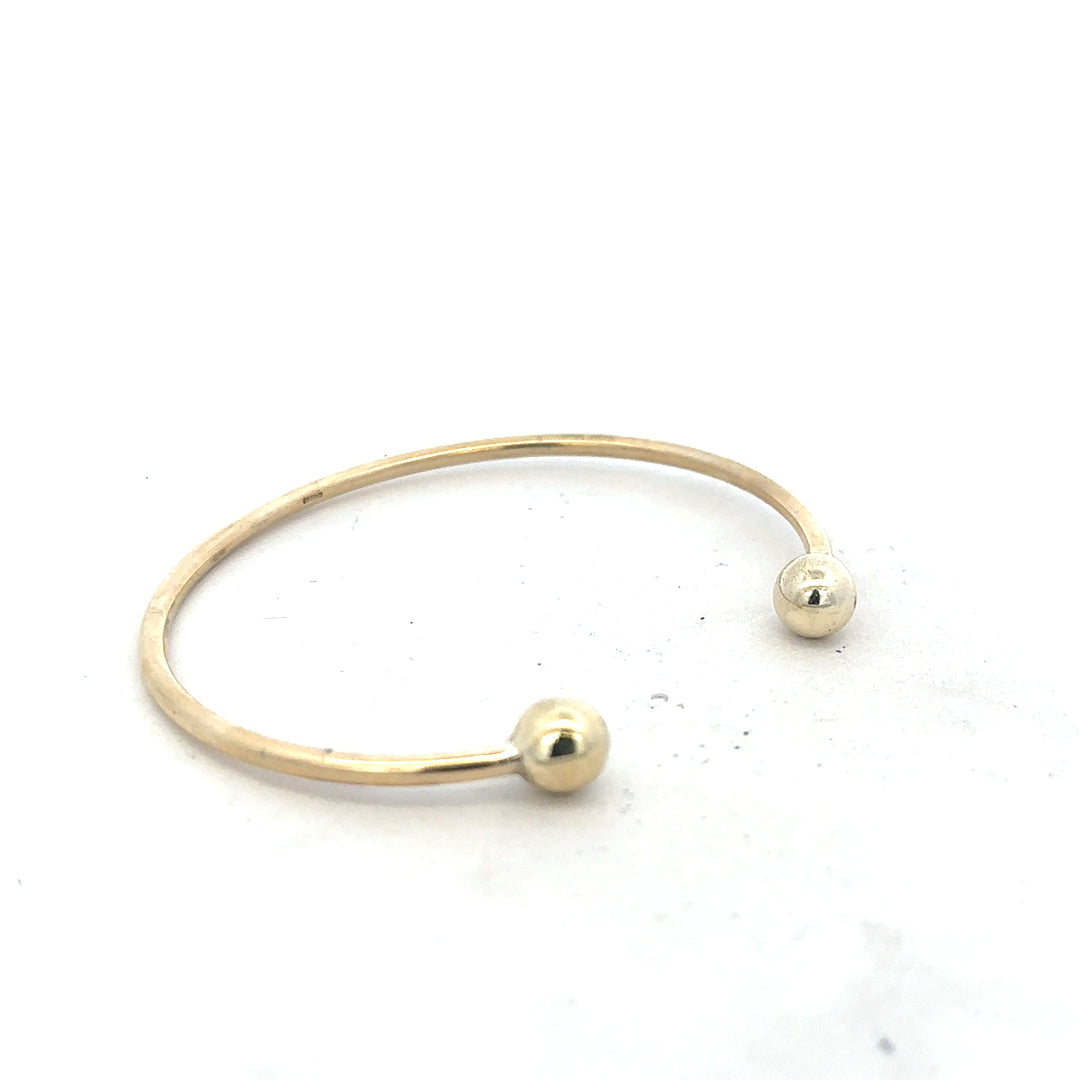 9ct yellow gold bangle bracelet weighing 12.7g, unbranded, with a smooth polished finish and rounded design.