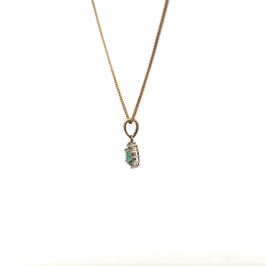 9ct yellow gold chain with emerald and diamond pendant, showcasing a delicate design and sparkling gemstones.