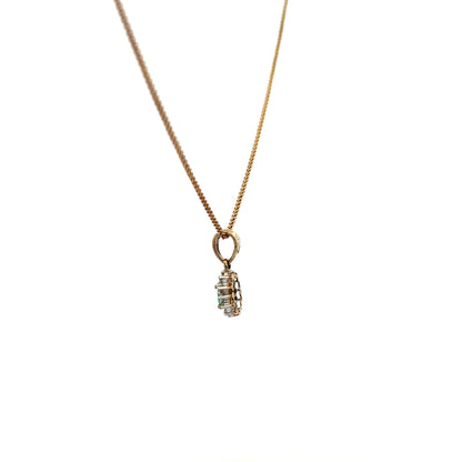 9ct yellow gold pendant with emerald and diamond accents, featuring a delicate chain and intricate design.