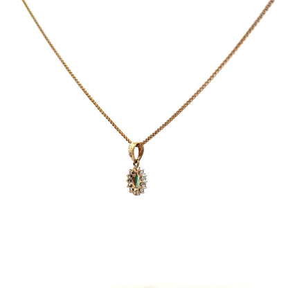 9ct yellow gold chain with emerald and diamond pendant, showcasing a detailed gemstone design and elegant craftsmanship.