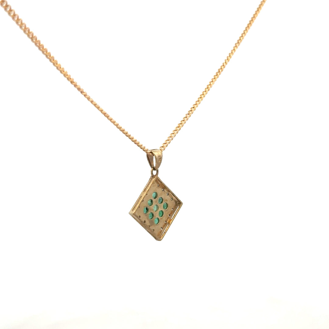 9ct yellow gold chain with emerald and diamond pendant, showcasing a detailed floral design and sparkling gemstones.