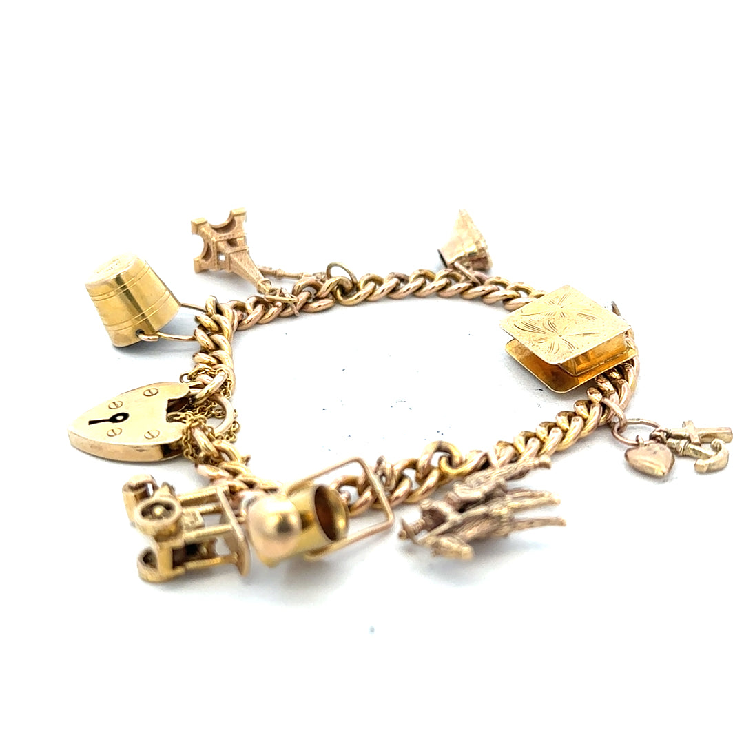9ct yellow gold charm bracelet weighs 28.1g, featuring decorative charms and a secure clasp, crafted in unbranded jewelry style.