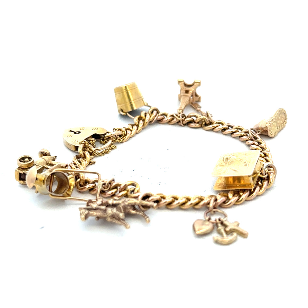 9ct yellow gold charm bracelet weighing 28.1g, unbranded, with intricate charm details visible on a sleek jewelry style.