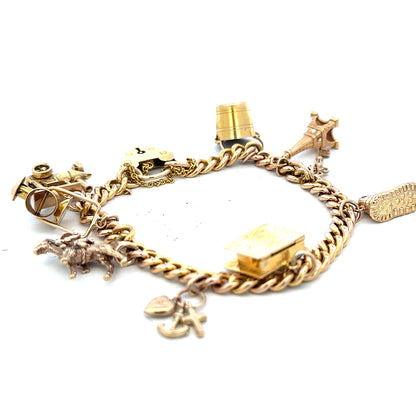 9ct yellow gold charm bracelet weighing 28.1g, unbranded, with detailed charms visible on a sleek gold chain.