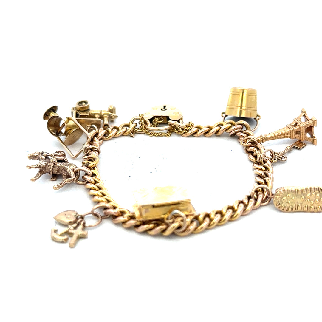 9ct yellow gold charm bracelet weighing 28.1g, unbranded, with detailed charms and a secure clasp.