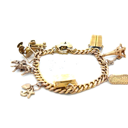 9ct yellow gold charm bracelet weighing 28.1g, unbranded, with detailed charms and a secure clasp.