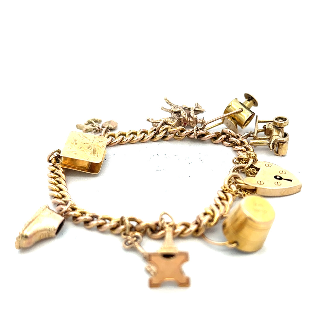 9ct yellow gold charm bracelet with intricate design, weighs 28.1g, featuring various charms, unbranded jewelry accessory.