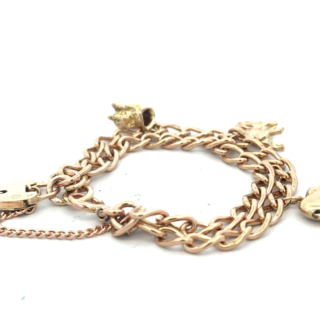 Unbranded 9ct yellow gold charm bracelet weighing 28.5g with intricate charm details and polished finish.