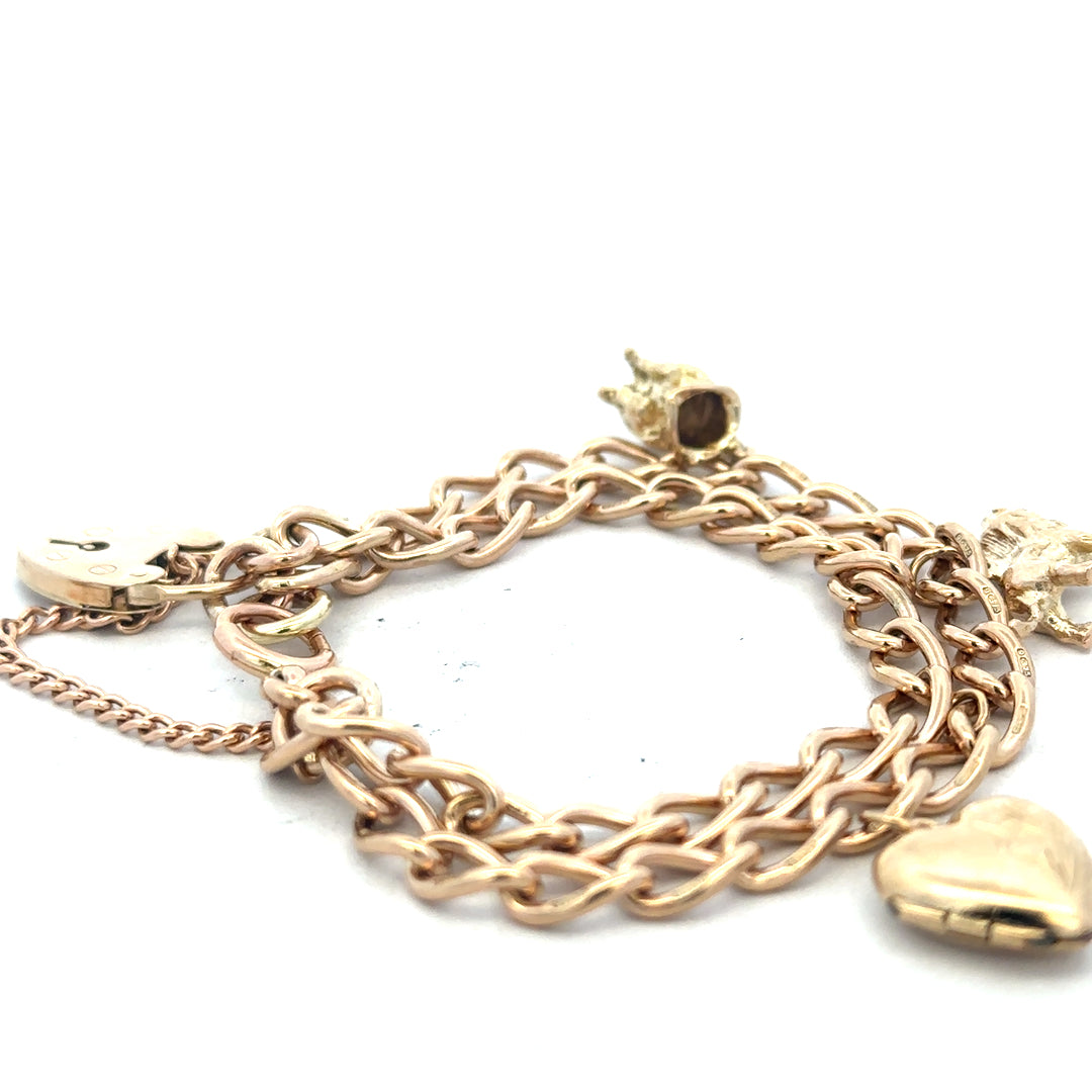 9ct yellow gold charm bracelet with intricate design, weighing 28.5g, featuring various decorative charms and a secure clasp.