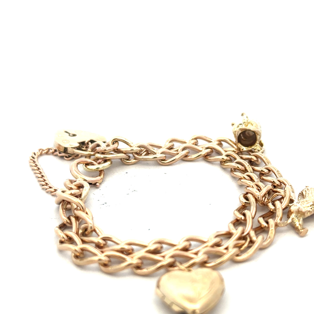 9ct yellow gold charm bracelet weighing 28.5g with intricate charms, unbranded, showcasing fine gold craftsmanship.