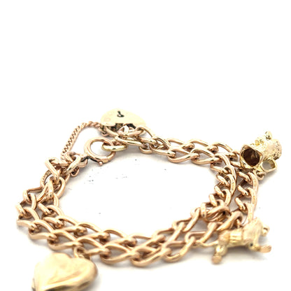 9ct yellow gold charm bracelet with detailed charms, unbranded, weighing 28.5g, displayed on a neutral background.
