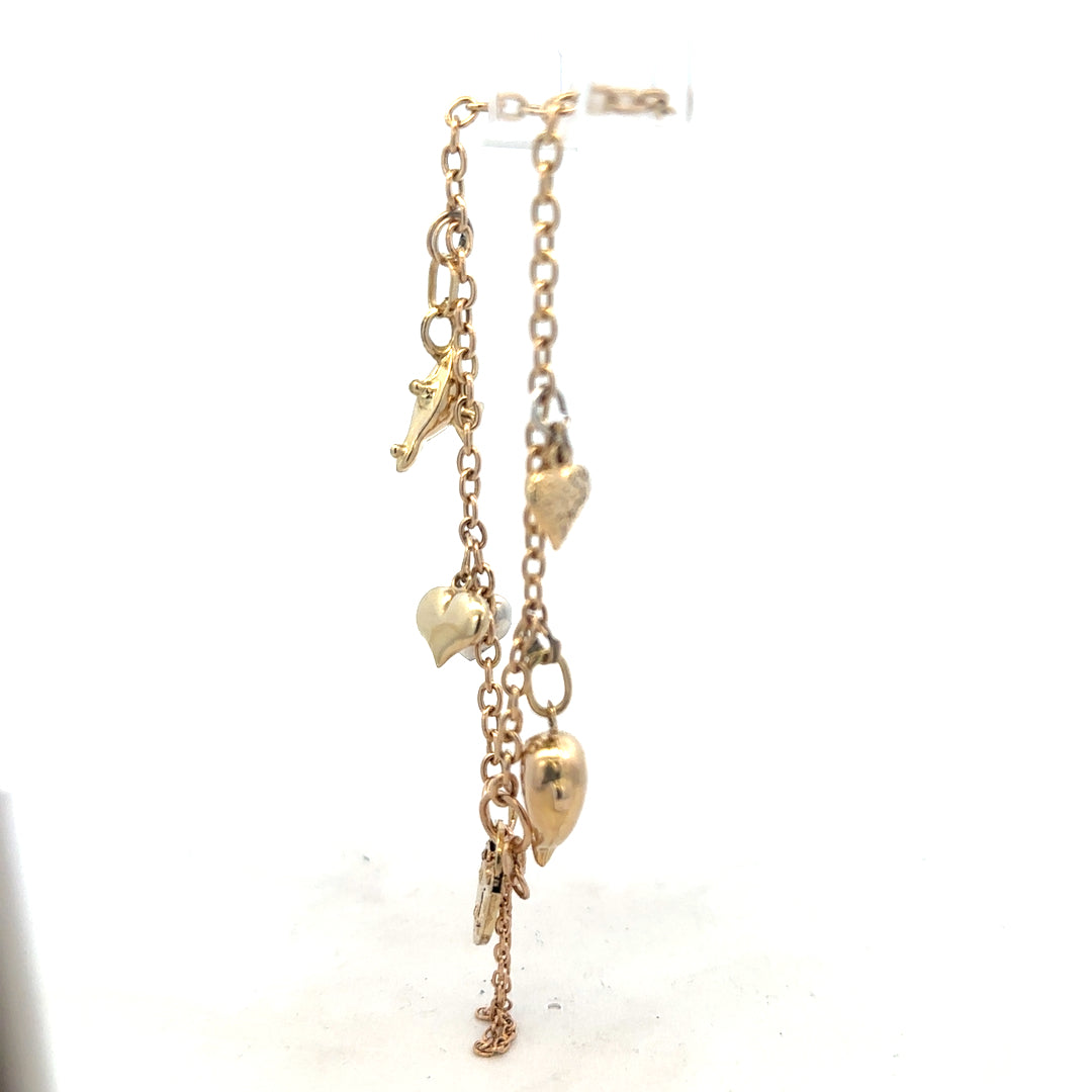 9ct yellow gold charm bracelet weighing 5.4g, featuring decorative charms on an unbranded jewelry piece.