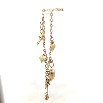 9ct yellow gold charm bracelet weighing 5.4g, featuring decorative charms on an unbranded jewelry piece.