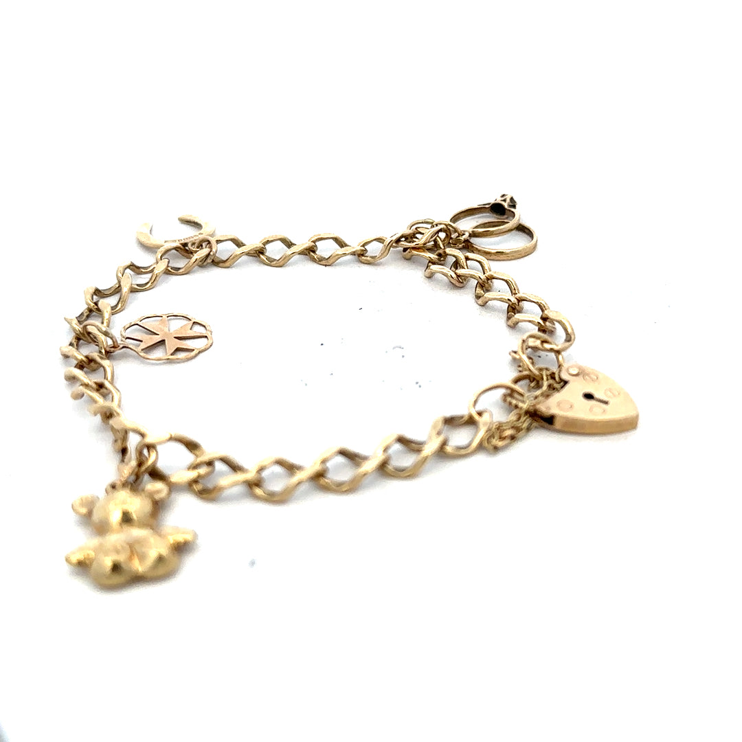 9ct yellow gold charm bracelet with intricate designs, weighing 9.9 grams, featuring detailed charms on a classic gold bracelet.