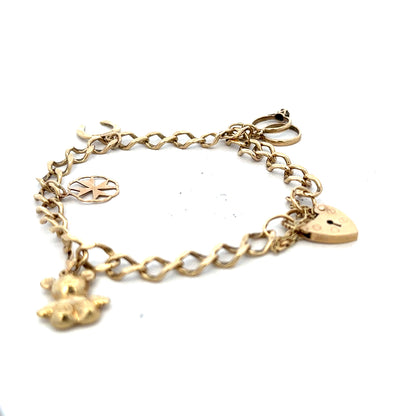 9ct yellow gold charm bracelet with intricate designs, weighing 9.9 grams, featuring detailed charms on a classic gold bracelet.
