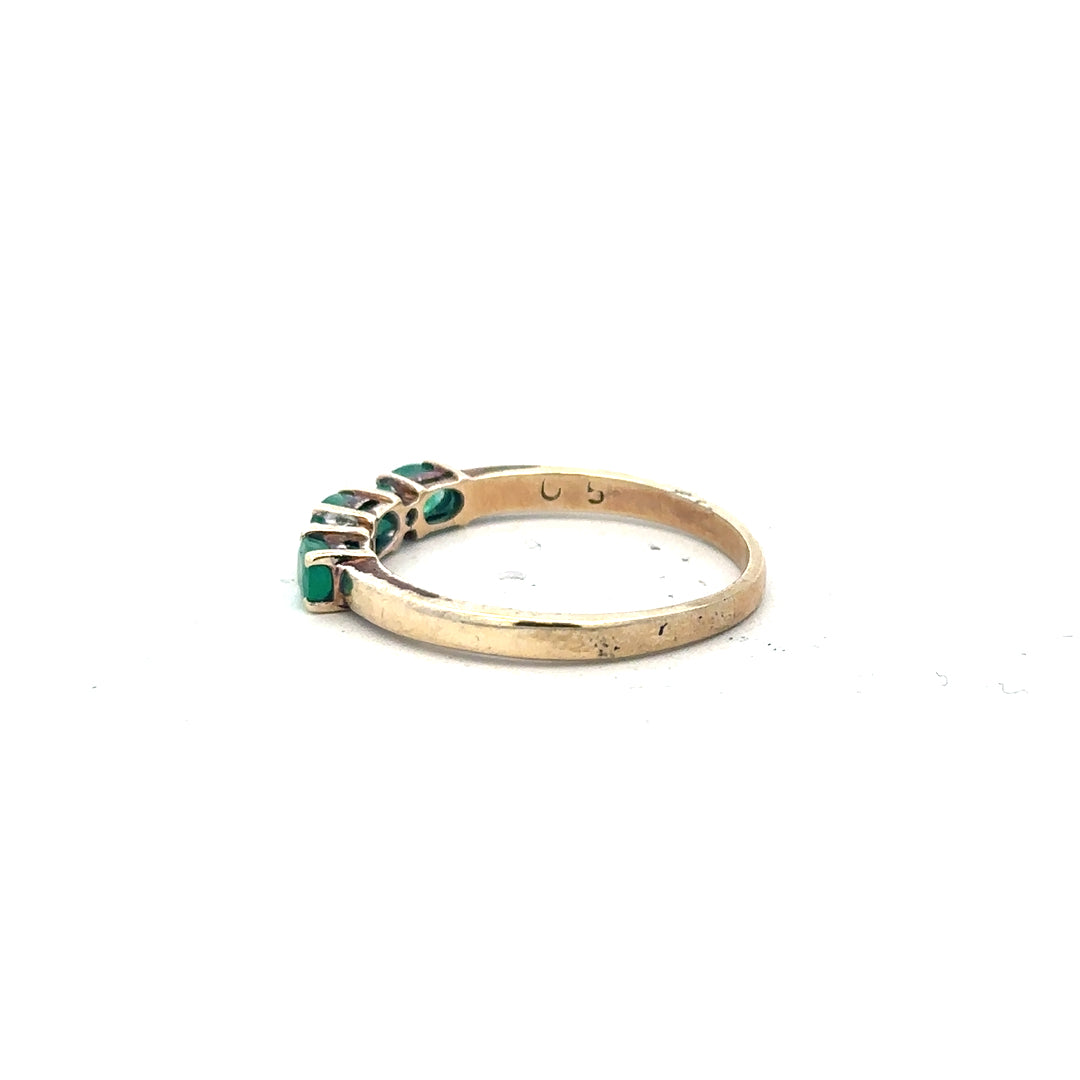 9ct yellow gold emerald and diamond ring in size T, featuring a central emerald gemstone surrounded by small diamonds.