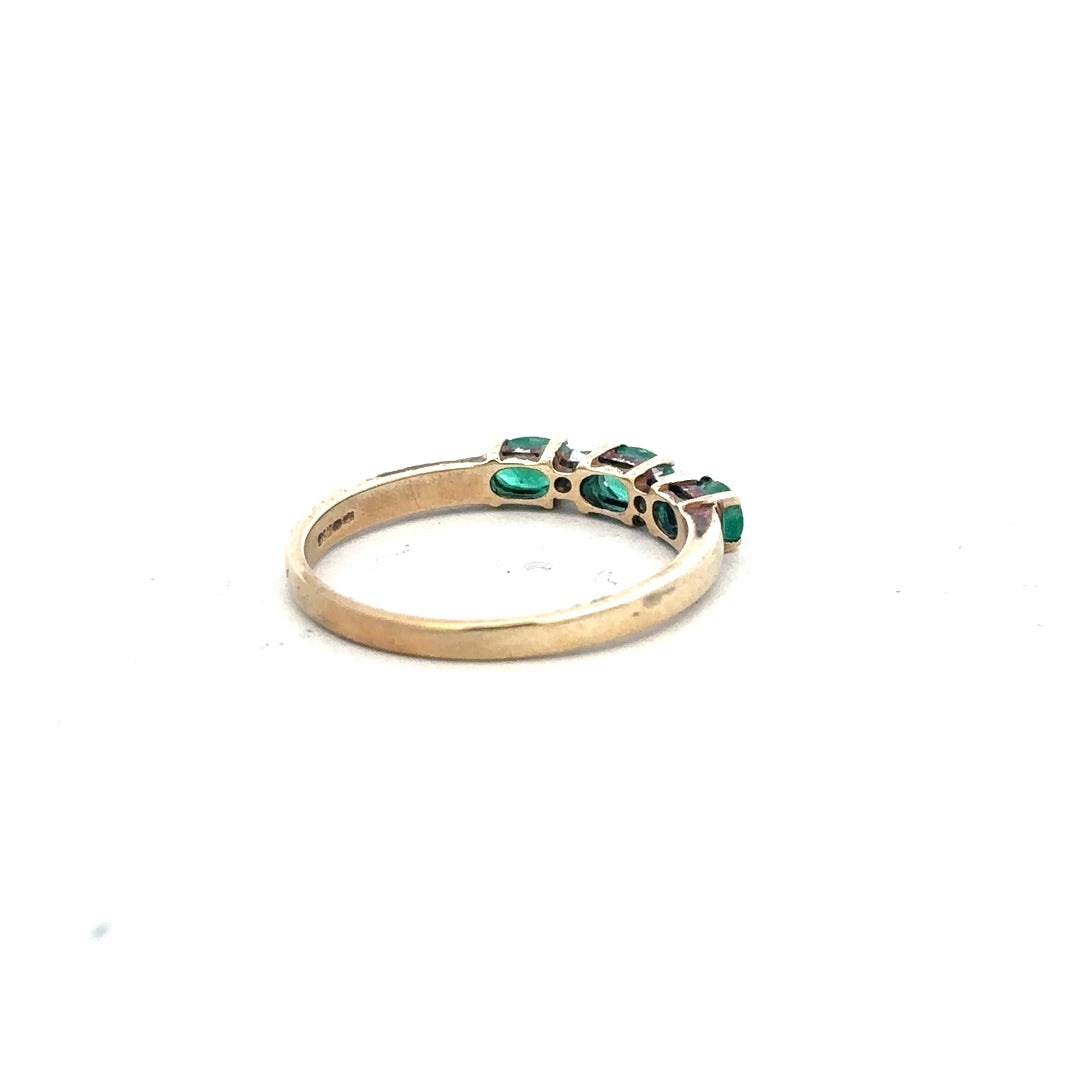 9ct yellow gold emerald and diamond ring in size T, featuring a central emerald with diamond accents on a gold band.