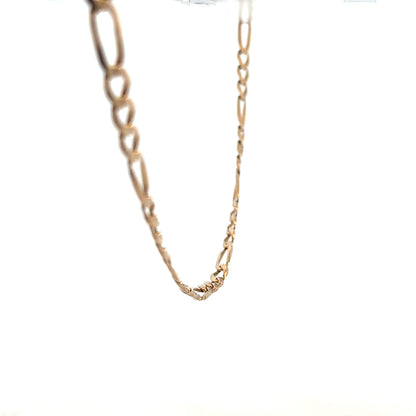 9ct yellow gold Figaro chain, unbranded, showcasing its detailed linked design and polished finish on a plain background.