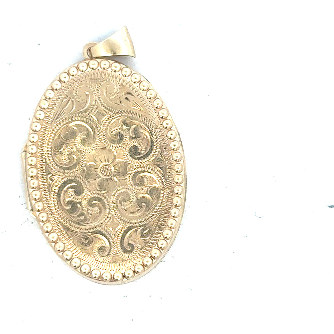 9ct yellow gold locket pendant, unbranded, weighing 6.3g, featuring intricate design, displayed in a close-up shot.