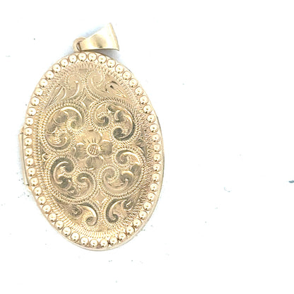 9ct yellow gold locket pendant, unbranded, weighing 6.3g, featuring intricate design, displayed in a close-up shot.