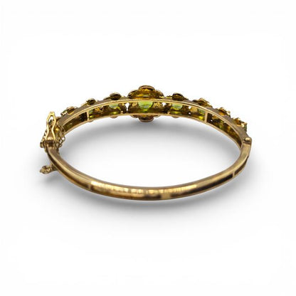 9ct yellow gold peridot bangle bracelet with vibrant green gemstones on a sleek gold band.