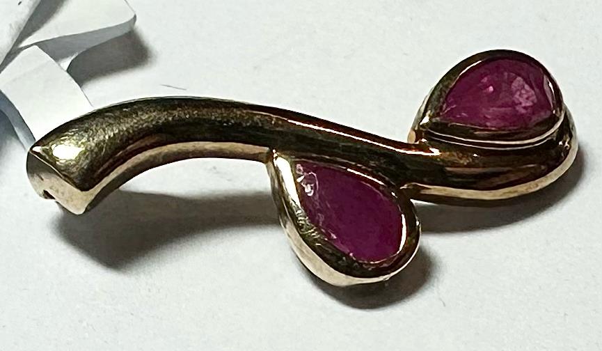 9ct yellow gold ruby pendant with a central gemstone, weighing 1.2g, featuring an elegant design in a natural jewelry style.