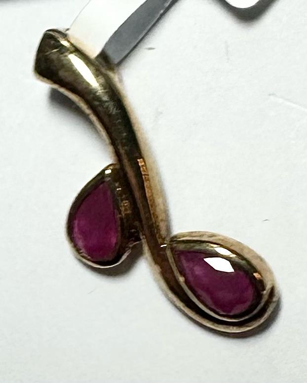 9ct yellow gold ruby pendant featuring a vibrant red gemstone, designed with a delicate chain for elegant jewelry.