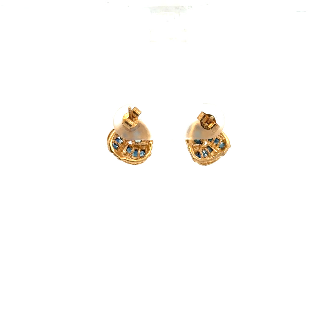 9ct yellow gold sapphire earrings with a delicate design, shown resting on a white background. Unbranded jewelry.