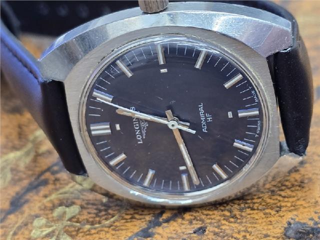 Unbranded Longines 1972 Munich Olympics watch with gold-tone case, black leather strap, and vintage Olympic logo on dial.