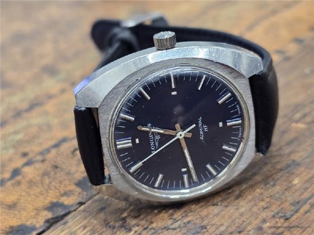 Longines 1972 Munich Olympics watch with gold-tone case and black leather strap, showcasing vintage sports design.