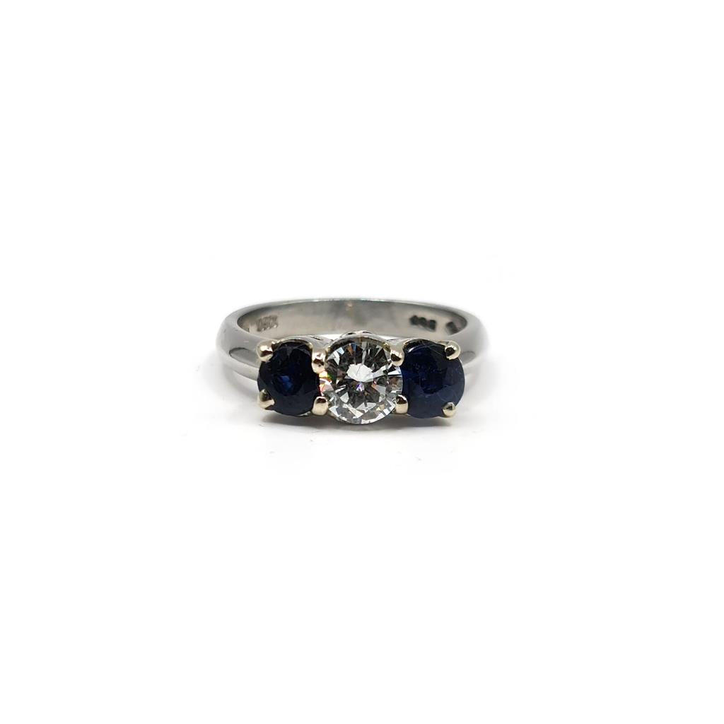 Platinum ring featuring a 1/2 carat diamond and 0.80 carat sapphire gemstone, set in an elegant, unbranded jewelry design.