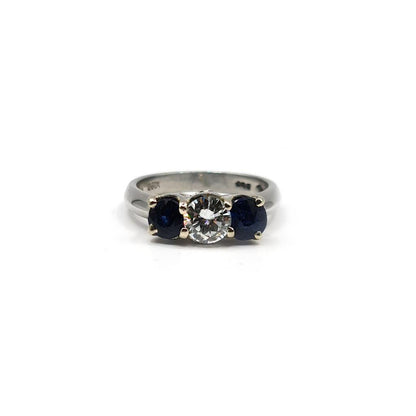 Platinum ring featuring a 1/2 carat diamond and 0.80 carat sapphire gemstone, set in an elegant, unbranded jewelry design.