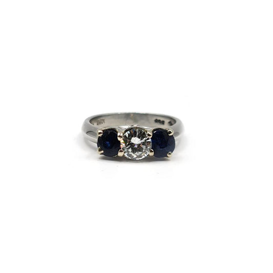 Platinum ring featuring a 1/2 carat diamond and 0.80 carat sapphire gemstone, set in an elegant, unbranded jewelry design.