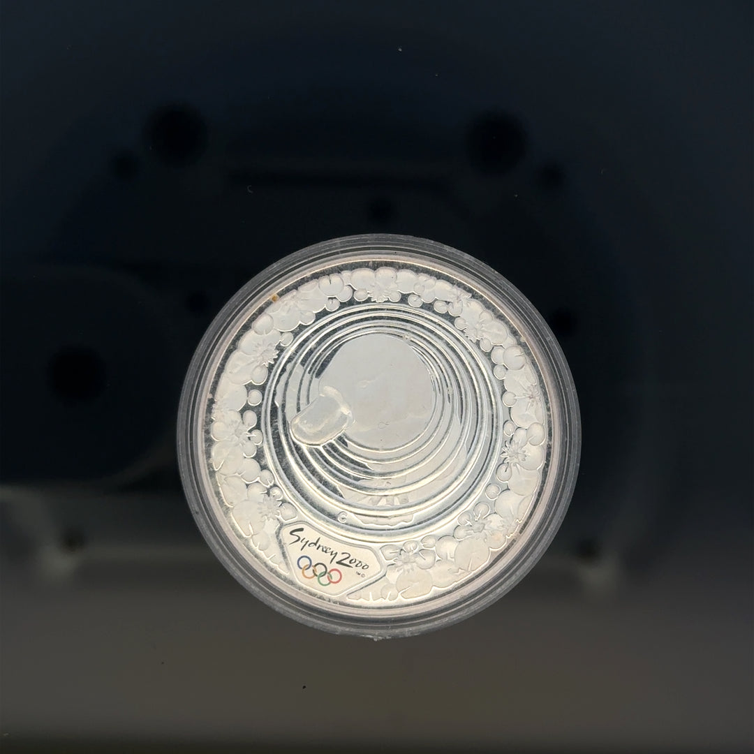 Silver 2000 Olympic coin, 31.4g, featuring Olympic design, unbranded collectible silver coin with detailed engravings.