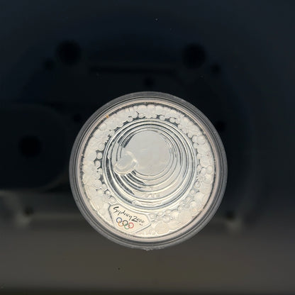Silver 2000 Olympic coin, 31.4g, featuring Olympic design, unbranded collectible silver coin with detailed engravings.