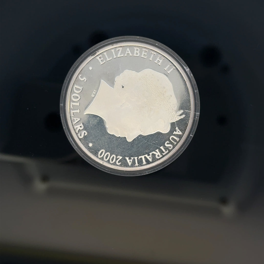 Silver 2000 Olympic coin, 31.4g, featuring Olympic imagery, unbranded, detailed design, collectible silver coin.
