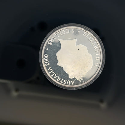 Silver 2000 Olympic coin, 31.4g, featuring Olympic design, unbranded collectible silver coin with detailed engravings.