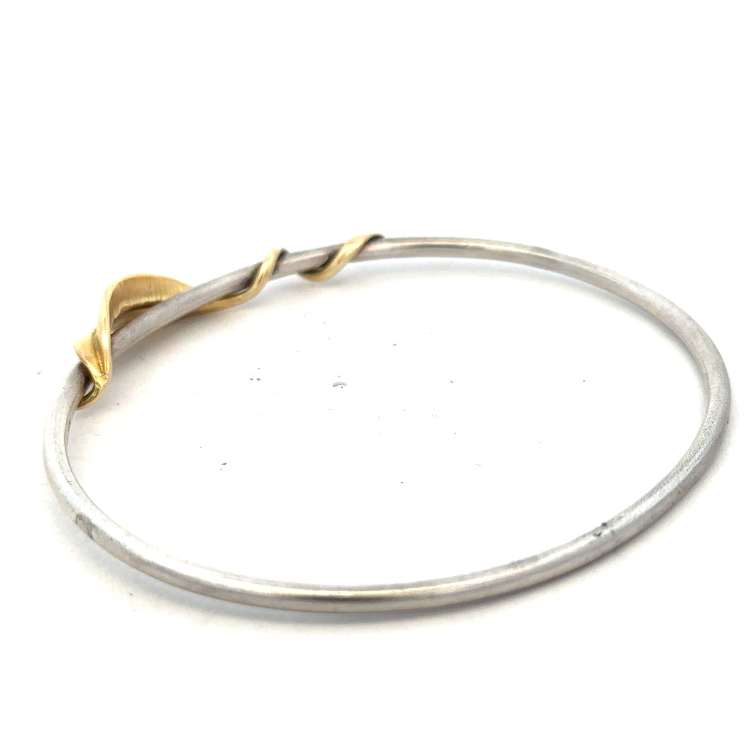 Silver bangle bracelet weighing 13.3g with a smooth, polished finish, showcasing a sleek unbranded jewelry design.