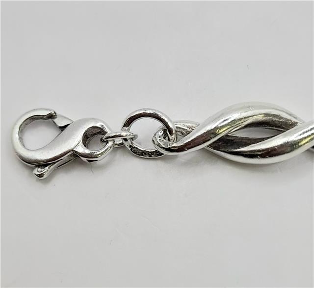 Silver bracelet, 19cm length, 14.4g, unbranded jewelry with a sleek, polished design shown in the image.