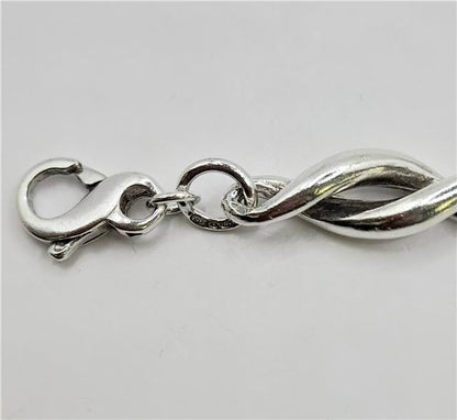 Silver bracelet, 19cm length, 14.4g, unbranded jewelry with a sleek, polished design shown in the image.