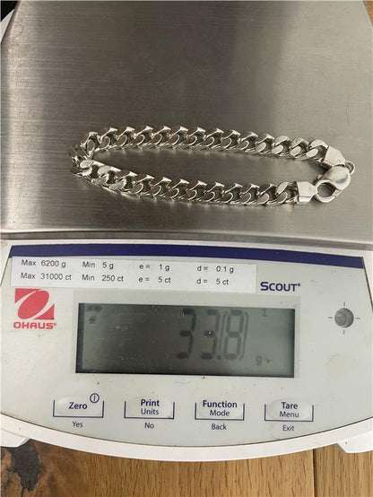 Silver bracelet weighing 33.8g with a sleek design, unbranded jewelry accessory, visible on a neutral background.