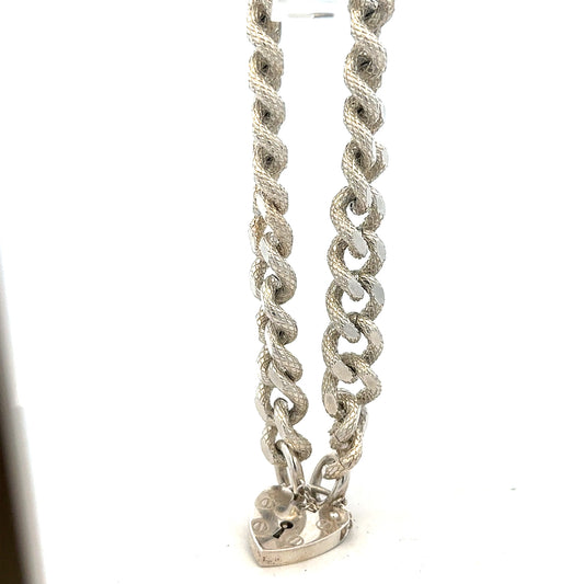 Silver bracelet weighing 64.4g with intricate design, unbranded jewelry accessory, shown on a plain background.