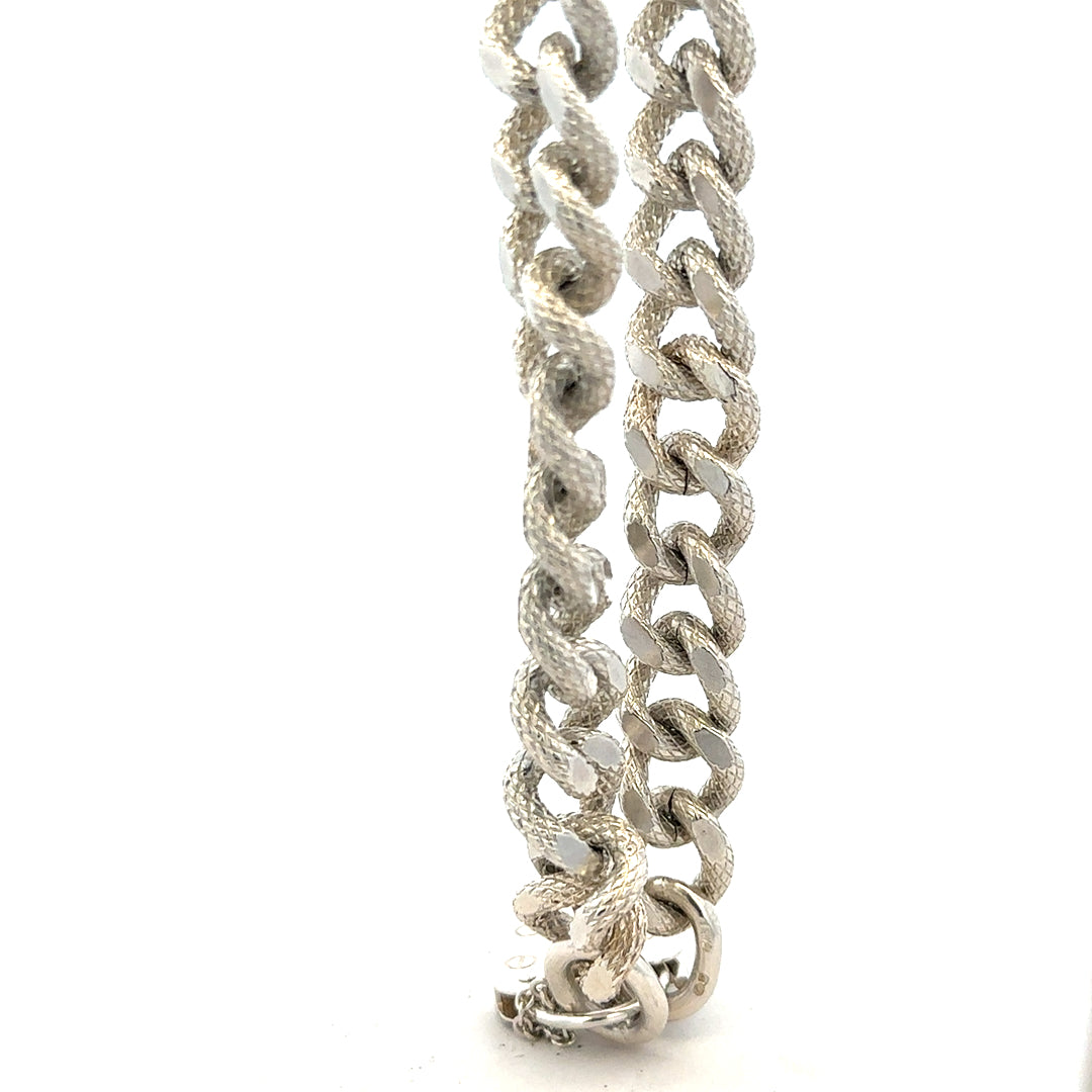 Silver bracelet weighing 64.4g with intricate design, unbranded jewelry piece featuring a sleek, polished finish.