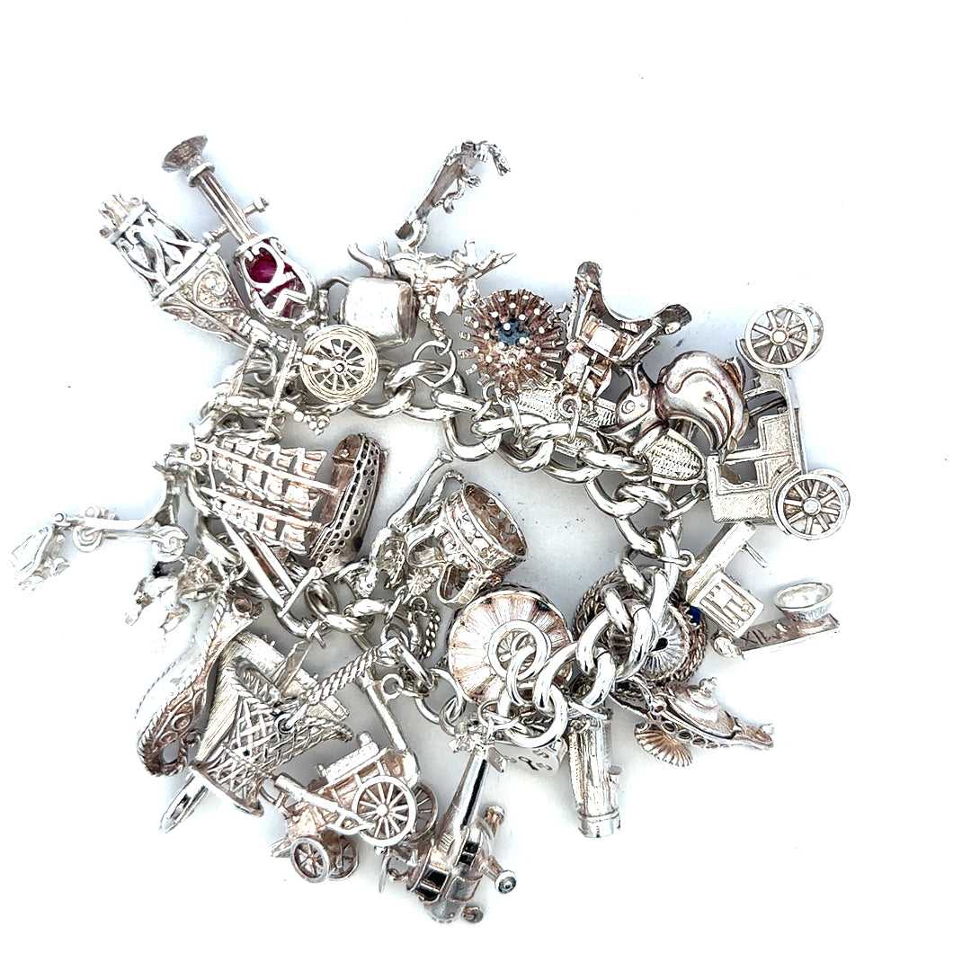 Silver charm bracelet weighing 154.4g, featuring decorative charms and a secure clasp, unbranded jewelry accessory.