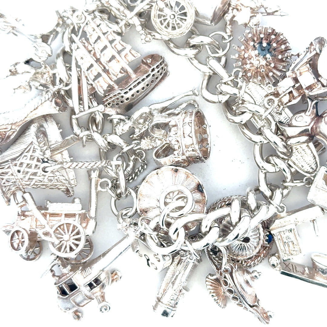 Silver charm bracelet weighing 154.4g, featuring various decorative charms, unbranded jewelry accessory for women.