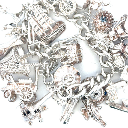 Silver charm bracelet weighing 154.4g, featuring various decorative charms, unbranded jewelry accessory for women.