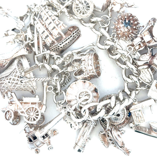 Silver charm bracelet weighing 154.4g, featuring various decorative charms, unbranded jewelry accessory for women.