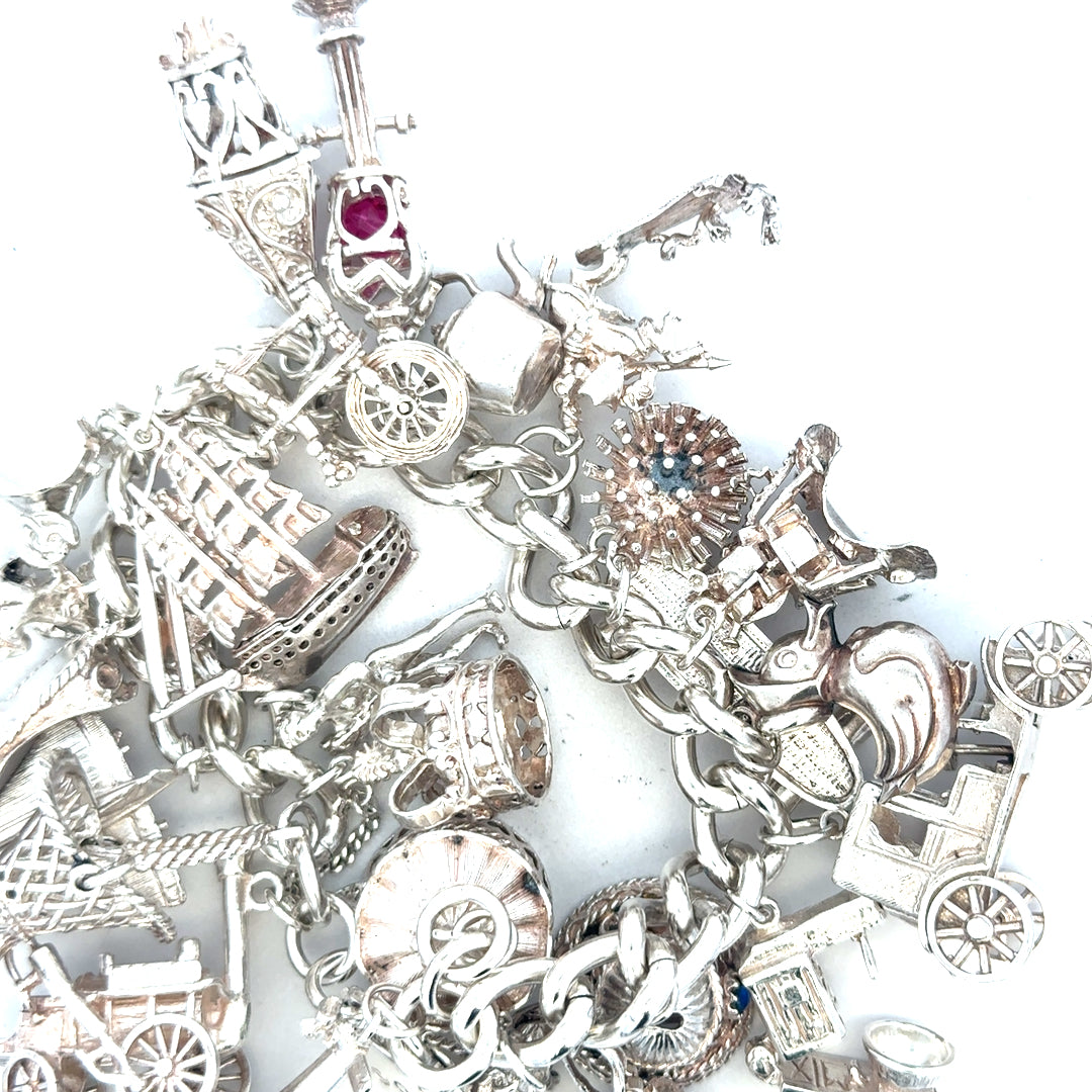 Silver charm bracelet weighing 154.4g with various decorative charms, unbranded jewelry accessory for women.