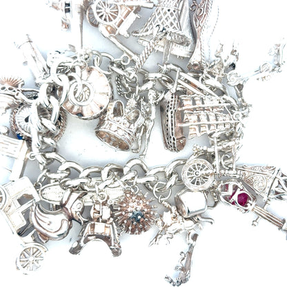 Silver charm bracelet weighing 154.4g with decorative charms, unbranded jewelry accessory, displayed on a plain background.